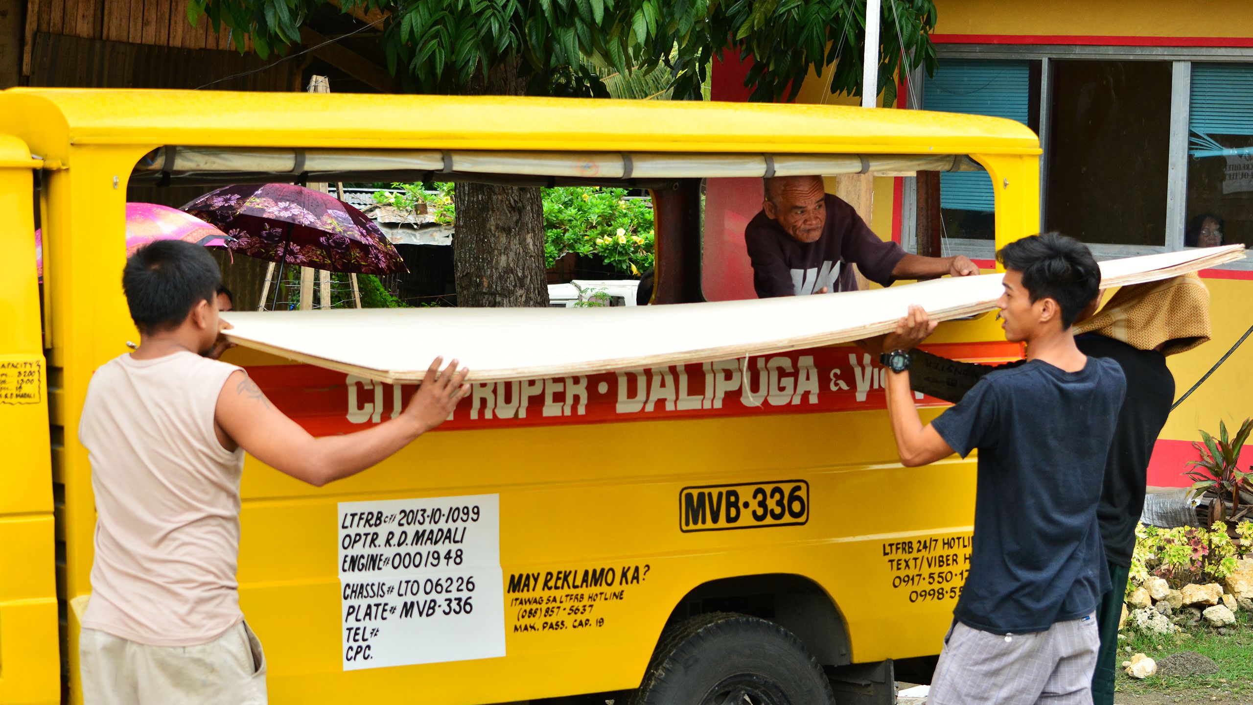 Ma April R. dela Cruz / Catholic Relief Services, Start Fund alert 165 Philippines. People are seen loading up a rented vehicle with shelter kits they received.