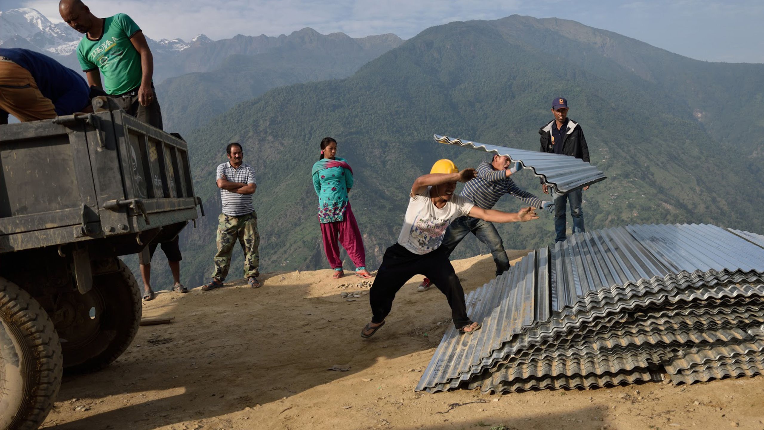 Lucy Beck / CARE, iron sheets are seen being unloaded, part of the Transforming Surge Capacity project in Nepal. Part of the wider DEPP programme.
