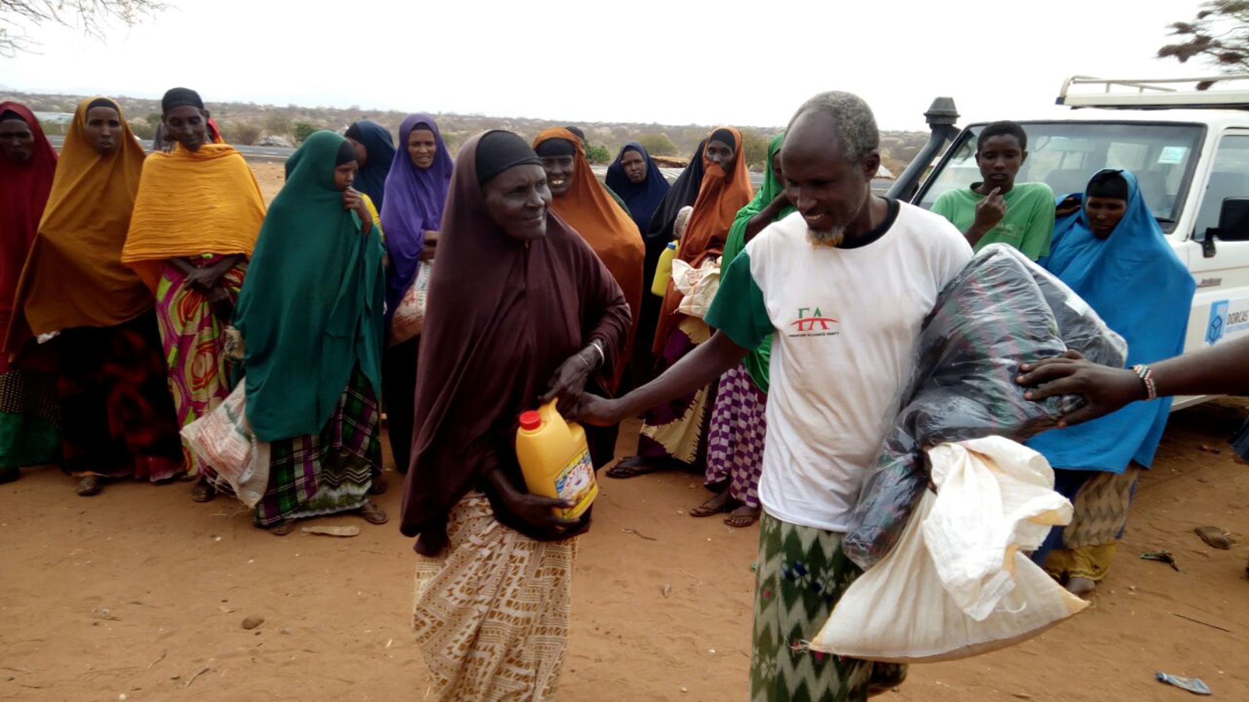 A Kenyan family is seen receiving food aid packages.