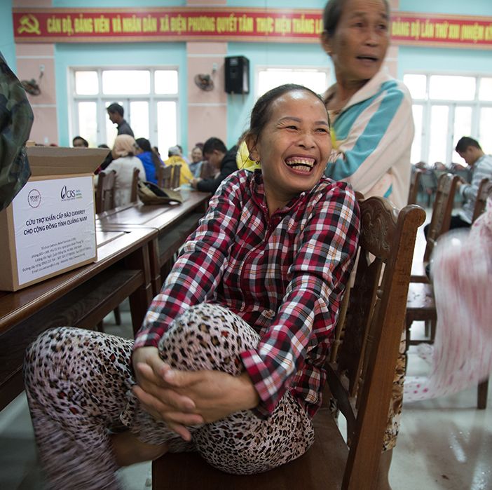A woman is seen receiving a hygiene kit as part of a typhoon response.