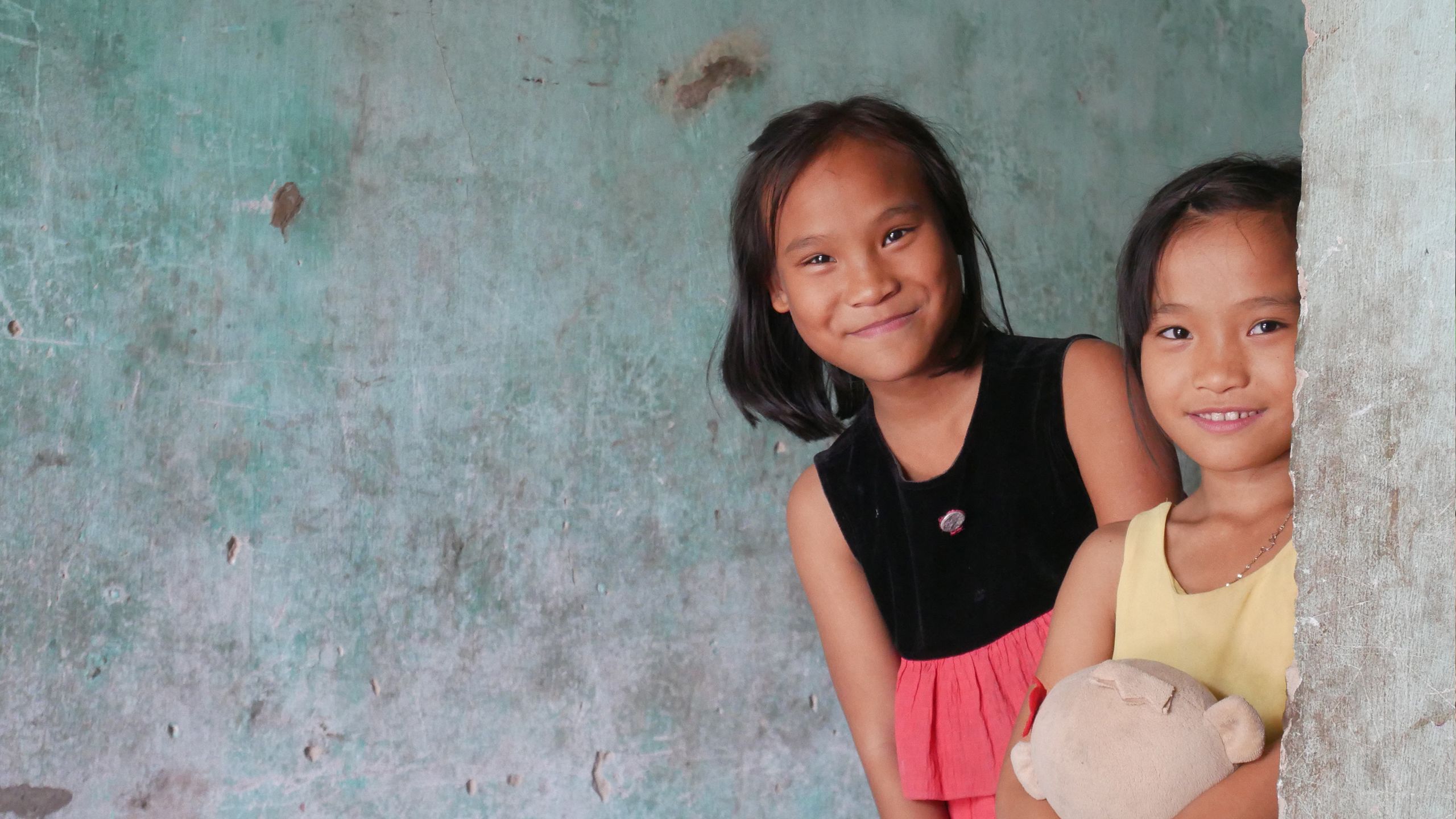 Two Vietnamese sisters are seen in their home after it was flooded by typhoon Damrey.